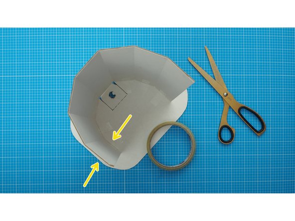 Using sellotape, stick 6 of the faceted edges to the top, leaving the middle facet unattached.