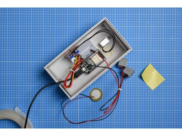 In most cases, the breadboard will already have a self-adhesive pad on the rear (use double-sided tape if not). Peel away the protective layer and stick the breadboard inside the box.