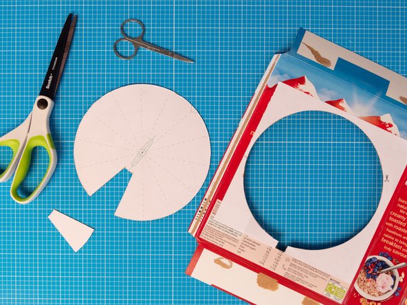 Very carefully create a hole in the square using a pointed tool such as a pen, a bradawl,  or the point of a compass.