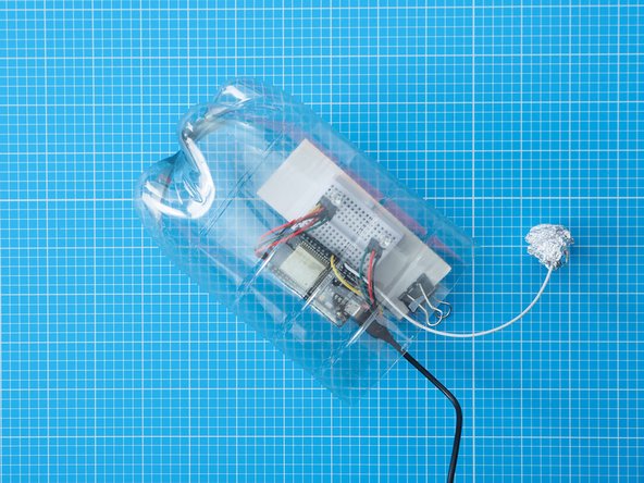 For a more secure and permanent bond you could use secure the breadboard assembly to the bottle with superglue, sugru or a hot glue gun.