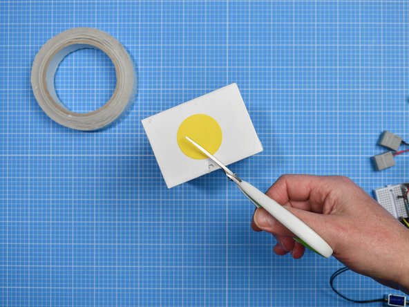 In the outer sleeve or lid of the phone box, cut a small triangle in one end, large enough for a USB lead to pass through.