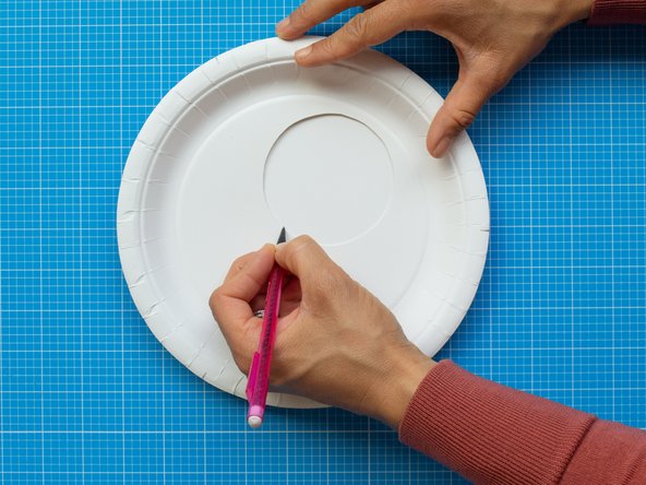 On a  new plate, mark the area of the window by placing the cut plate on top.  The marked circle will work as a white background for the LED lights of your device. This lighting area should remain clear.  All the electronic components will be placed around it.