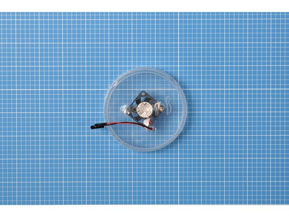 Place the fan, label side down, inside the lid, then pass the machine screws supplied with the fan through the other holes in the lid.