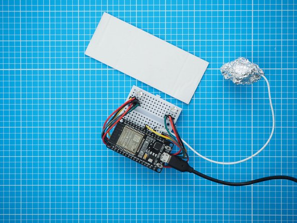 Mount the breadboard assembly on a small piece of cardboard that will fit inside the plastic bottle. The breadboard has a double sided tape backing which can be used to attach it.