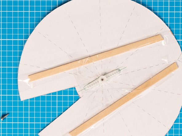 Carefully position the servo motor arm on the centre of the wheel, following the green outline on the template. Fix with tape or glue.