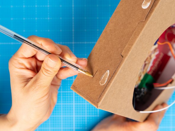 Mark a slit  for fitting a teaspoon on the top of the box.  The opening should be wide the enough to pass handle of a teaspoon through.