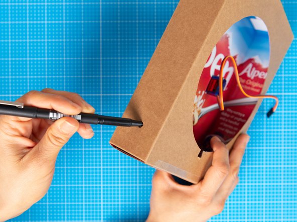 Pierce  the side of the box  with a pen or a pointy tool to make an opening.