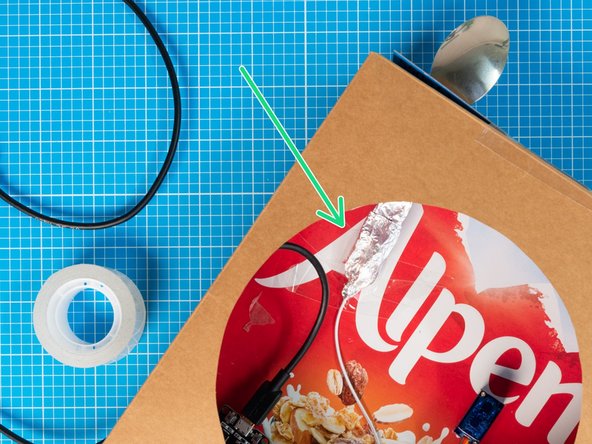 Connect the wrapped lead end to the spoon handle by wrapping both parts together with more kitchen foil. Once the connection is ready, it can be taped to the inside of the box to keep it in place.