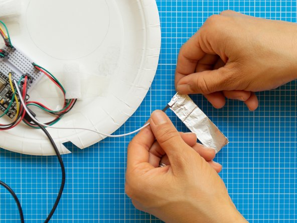 Take one end of the foil strip and wrap it around the pointy connector of the capacitive touch lead.