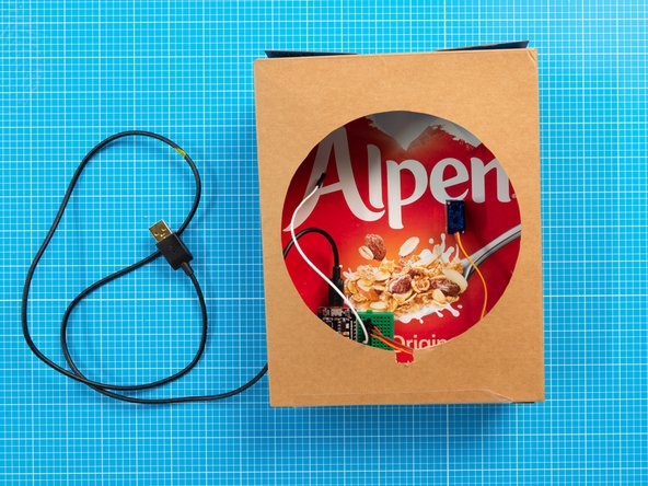 The breadboard has a double-sided tape backing which can be used to attach it to the inside fo the box.