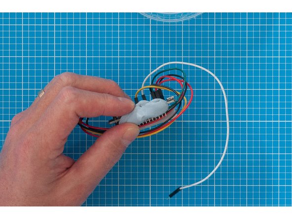 Attach the micro USB lead to the ESP32 board and carefully lower the assembly into the container, using the Blu Tack to support it.