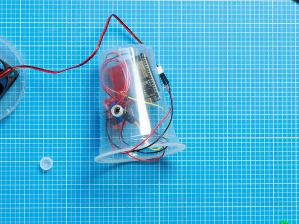 Fit the cap through the container hole from the front.