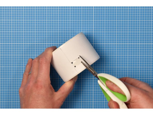 Using a bradawl or other sharp point, carefully make four holes in the four corners of the wrapper's notch.