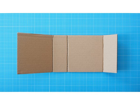 Score gently through only the top layer of the cardboard to create crease lines.  The fold lines should be made according to the guide; at 12cm, 17cm and  29cm mark.