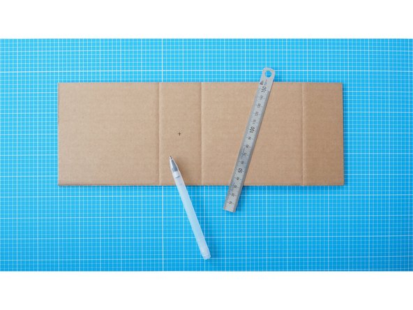 Turn the cardboard around and mark the middle of the 2nd segment as shown in the photograph.