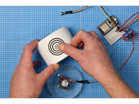 Fit the cap through the container hole from the front.