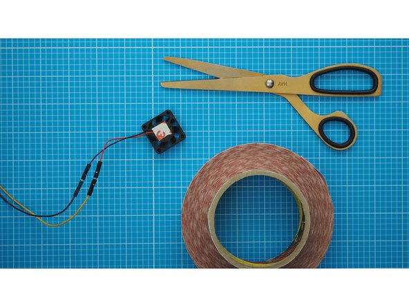 Attach the fan to the underside of the top cardboard, using double sided tape. The double-side tape should go on the side of the fan that does not rotate, which normally has a label.