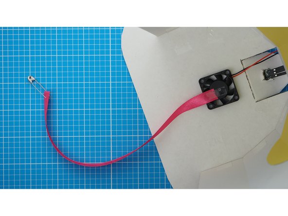 Secure the unweighted end to the centre of the fan using sellotape.