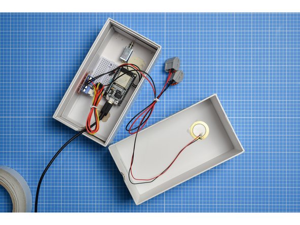 Attach a small piece of double-sided tape to the rear (the brass disc) of the piezo sensor and mount on the inside of the outer sleeve or lid of the box.