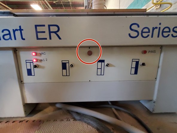 In the upper center of the machine frame front panel.