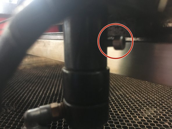 Locate the socket-head cap screw holding the lens tube into the mirror assembly.