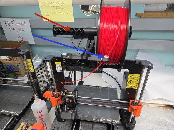 Take the filament and put it on the spool holder, making sure that it goes over the spool, and is guided through the filament guide.