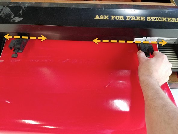 In the back, slide the pinch rollers to about one inch from each edge of the media.