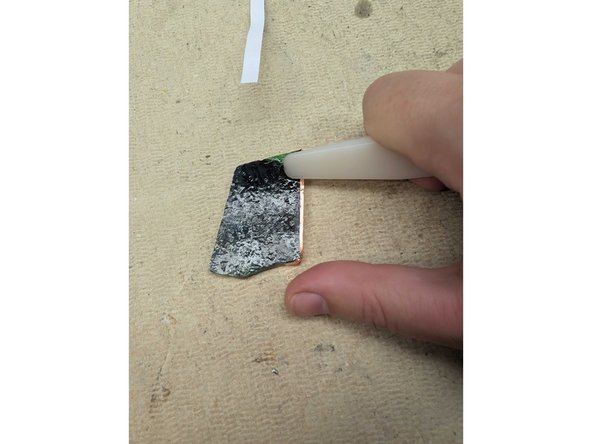 Peel the backing off a piece of copper foil, position the glass so the edge is centered, and stick the foil to the full circumference of your piece of glass. Cut the foil at the end.