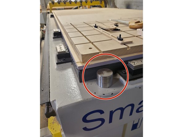 Clean off the round metal reference stud at the front of the machine bed.