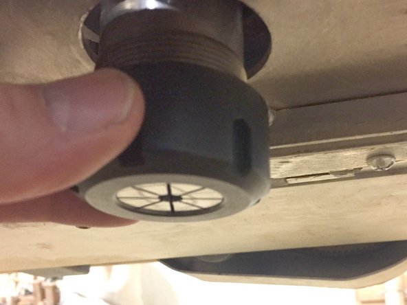 Install the collet on the spindle by starting the threads by hand.