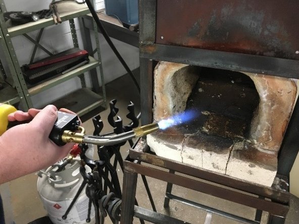 Keeping clear of the front forge opening (standing to the side with the Mapp Gas or Butane nozzle in the front forge opening) Light the torch and ignite the propane in the forge