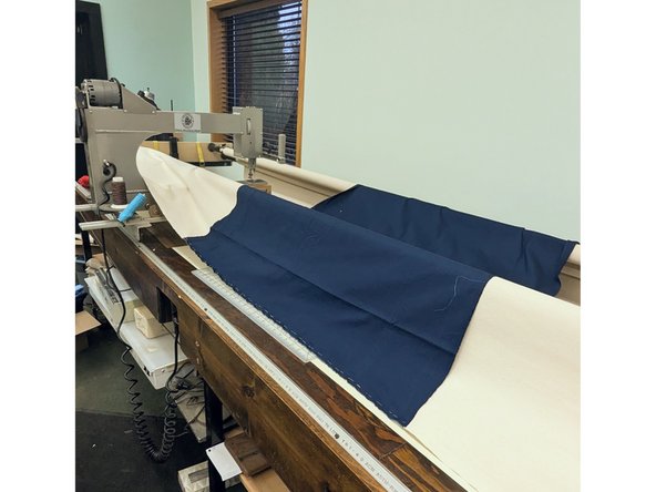 Place backing fabric wrong side up over the rollers. Line up center with mark on leader cloth on roller #1. Clamps can be used to hold it in place.