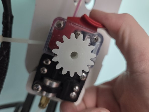 After the filament is past the tension lever release it and crank the tensioner knob counter clock wise until filament reaches the nozzle. The filament will be visible in the PTFE Tubing that leads to the hotend.