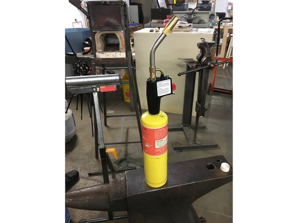 Retrieve the Mapp Gas or Butane bottle and Self-Lighting Nozzle from the hazardous materials cabinet.