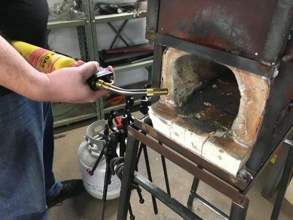 Keeping clear of the front forge opening (standing to the side with the Mapp Gas or Butane nozzle in the front forge opening) Light the torch and ignite the propane in the forge.