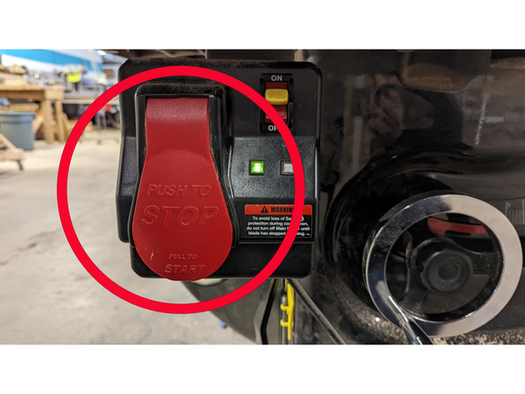 With your left hand, press the start button, grab the red handle on the miter gauge, and move your piece forward to make your cut.