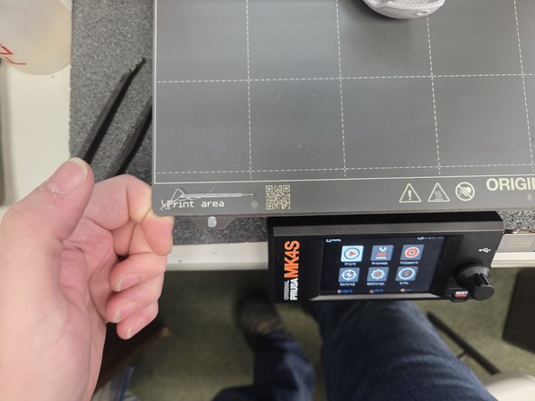 Remove the build plate from the printer. This can be done by positioning your index fingers like the first image, and positioning your thumbs over thumb print logos like the second image.