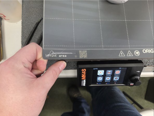 By pressing down with your thumbs on both sides the build plate will simply pop up.