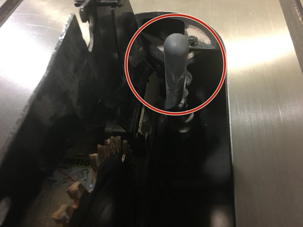 Locate the silver locking handle behind the blade on the right.