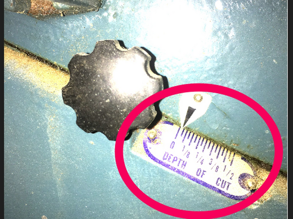 The scale below the table locking knob shows the current depth of cut.