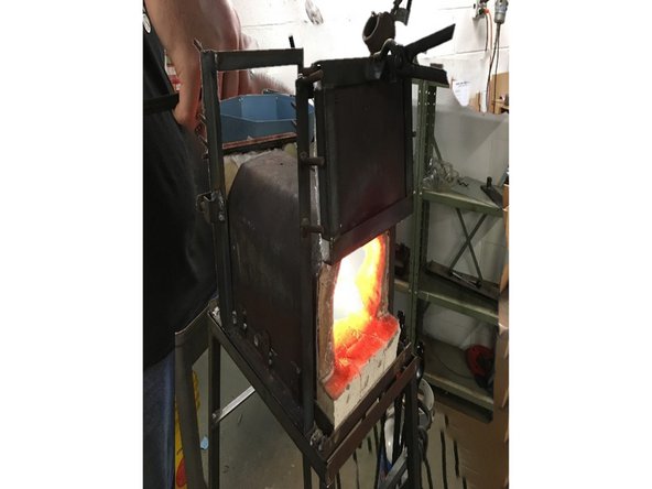 Using tongs, move front forge door to the top pegs.