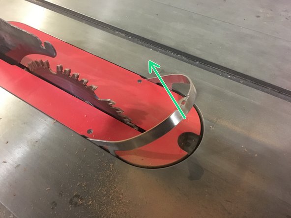 Pull up on this tab to release the throat plate's locking mechanism.