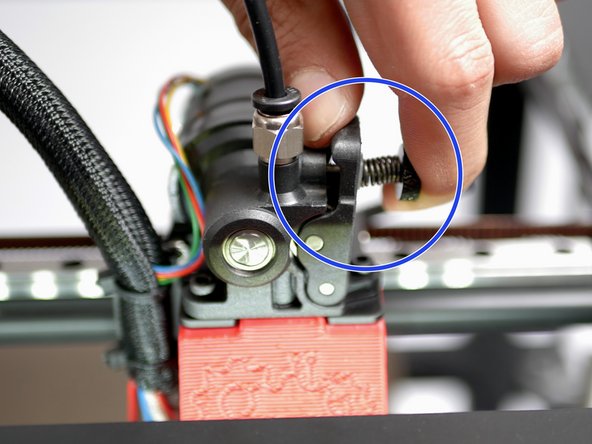 Put pressure on the extruder idler arm and continue to feed the filament into the hotend.