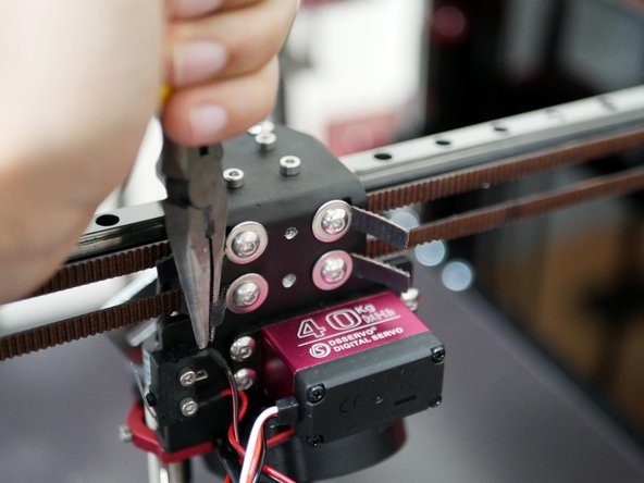 Loosen these bolts enough to be able to pull the belt with the pliers but also hold the tension without letting the belts slip back.