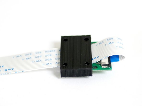 Slide the 3D Printed cover onto the Pi Cam with the ribbon cable looped over and sandwiched between them.