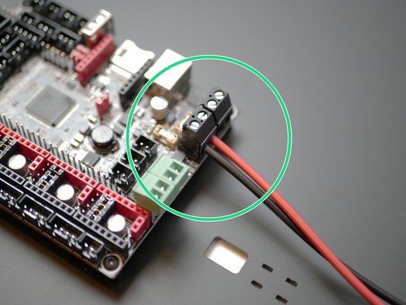 Secure the black and red power cables to the control board as shown.