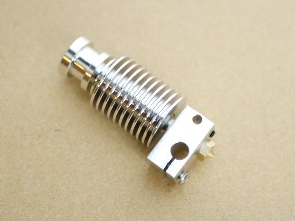 When tightening with the pliers hold the assembly from the heat sink and nozzle like shown in the second image.