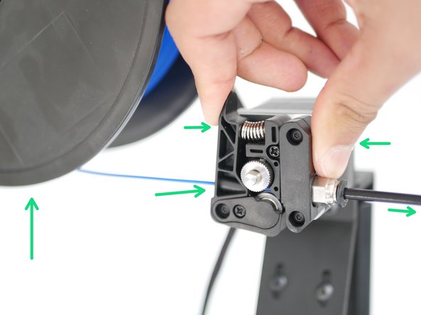 Place the spool onto the holder and feed the filament in through the extruder like shown, until it hits the bottom of the hotend.