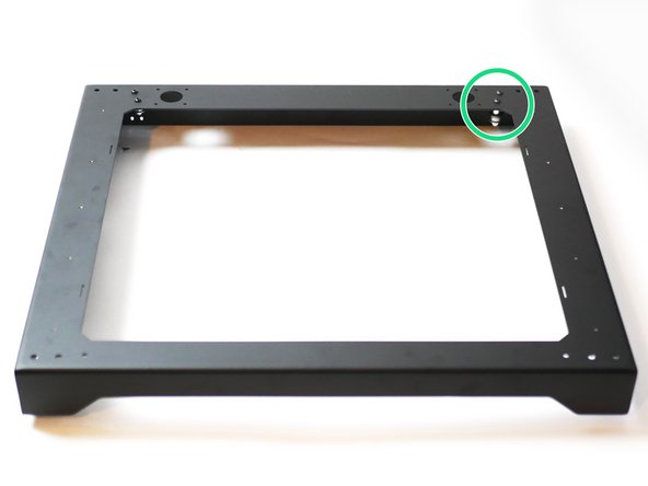 Install the two idler assemblies onto the rear right of the top panel as shown.