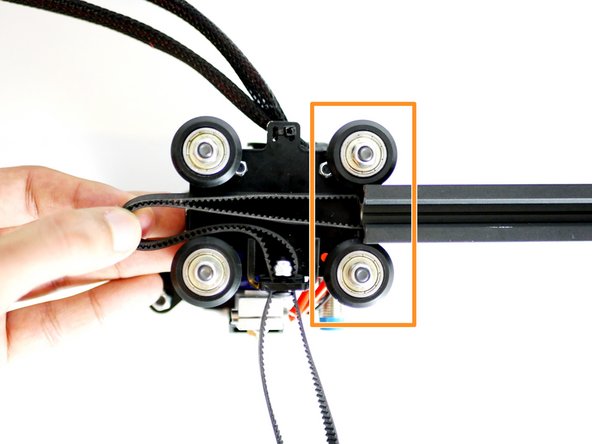 Bring the rollers up to the Y-Axis extrusion, trapping the belt in the grooves.